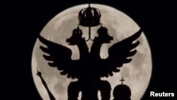 Россия -- Двухглавый орел, национальный символ России, на фоне полной луны над Музеем Истории в Москве, 10 августа 2014 год 