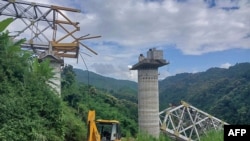 Ekipet e shpëtimit duke punuar në vendin e ngjarjes, ku një urë në ndërtim e sipër u shemb në Sairang në lindje të Indisë, më 23 gusht 2023.