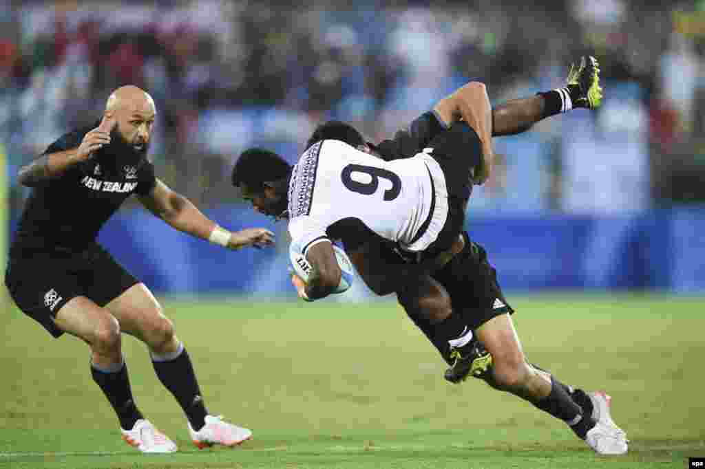 Jerry Tuwai of Fiji (front) fights for the ball with Akira Ioane of New Zealand during a men's rugby sevens quarterfinal match. Top-ranked Fiji defeated New Zealand 12 to 7.