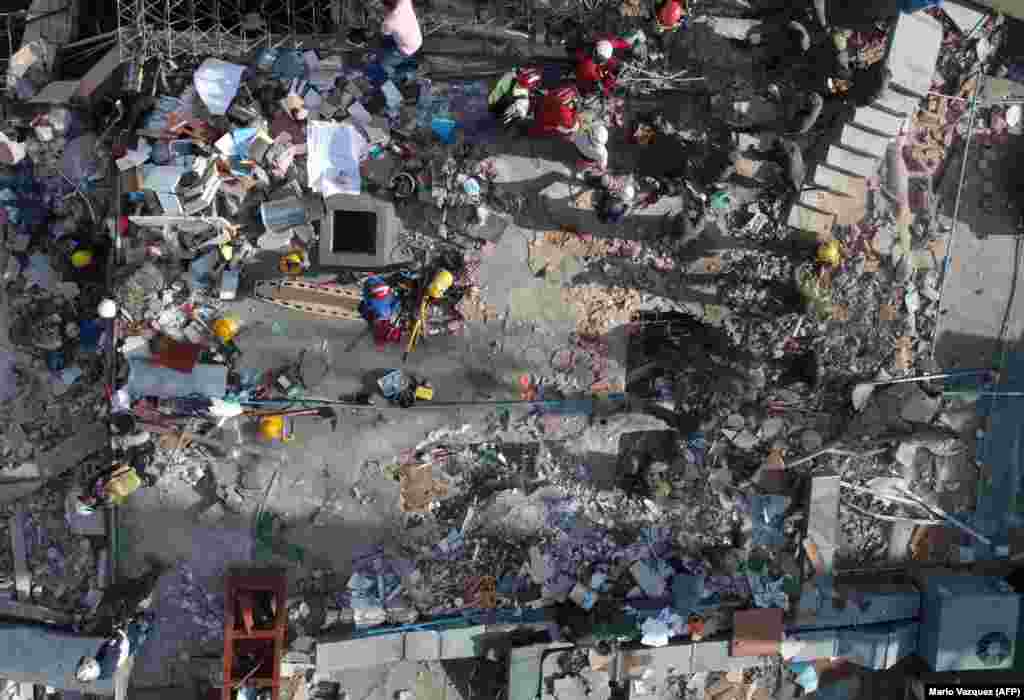 MEXICO -- Rescuers look for survivors in a multistory building flattened by a powerful quake in Mexico City on September 19, 2017.