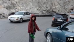 کودکی که در شاهراه کابل - جلال آباد موتر ها را تمیز میکند