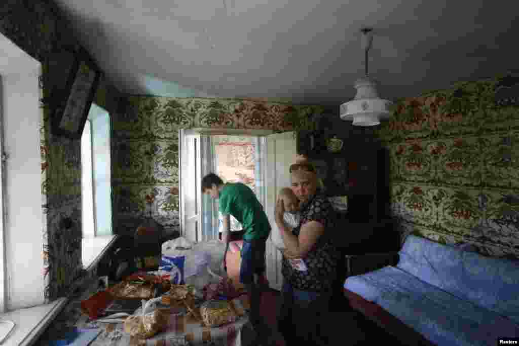 A family settles in their temporary accommodation in the town of Nyzhnya Krynka in eastern Ukraine.