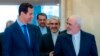 Syrian President Bashar al-Assad (left) speaks with Iranian Foreign Minister Mohammad Javad Zarif in Damascus on April 16. 