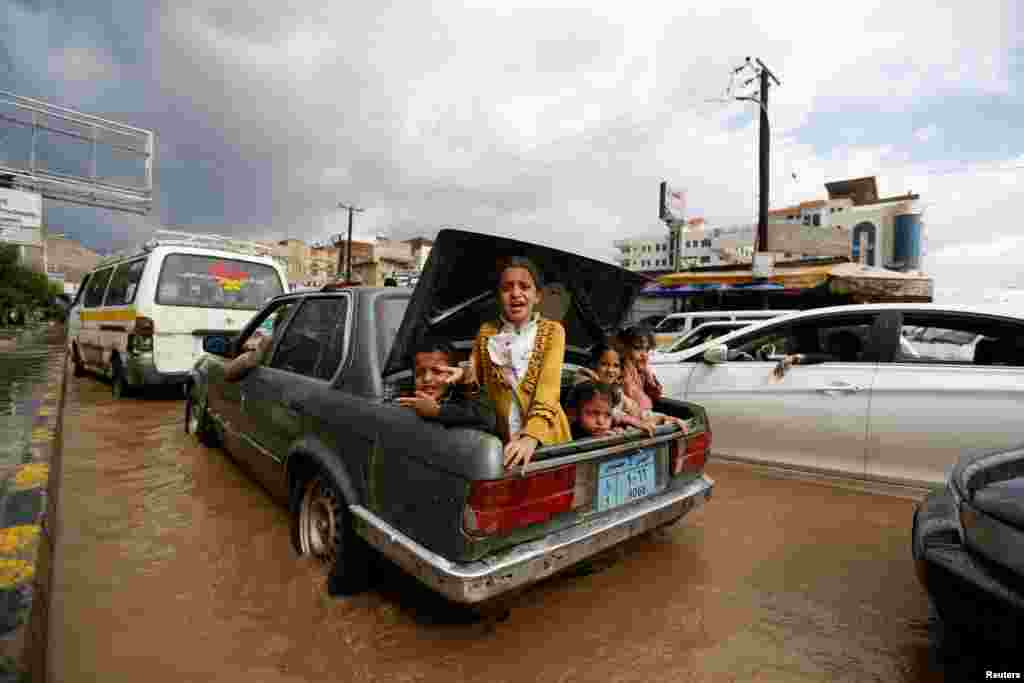 Children ride in the trunk of a car on a flooded street in Sanaa, Yemen. (Reuters/Khaled Abdullah)