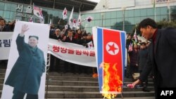 Южнокорейские протестующие сжигают северокорейский флаг.