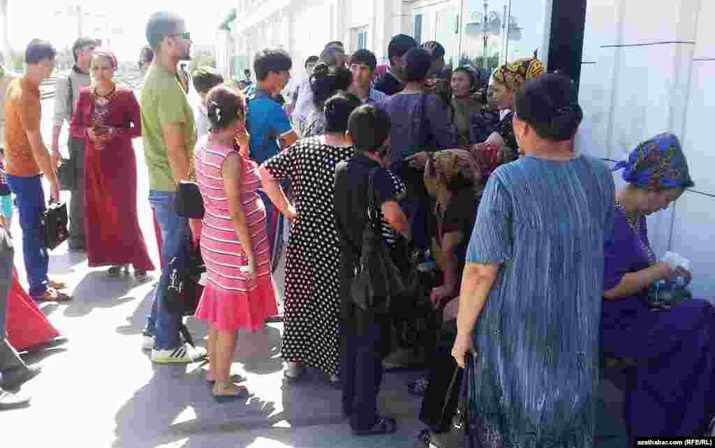 Türkmenabatdaky otly wokzalyndaky kassanyň öňünde adamlar bilet almaga synanyşýarlar.