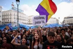 Участница акции протеста держит плакат с лозунгом "Справедливая арендная плата – сейчас" в Мадриде, Испания, 2 октября 2026 года