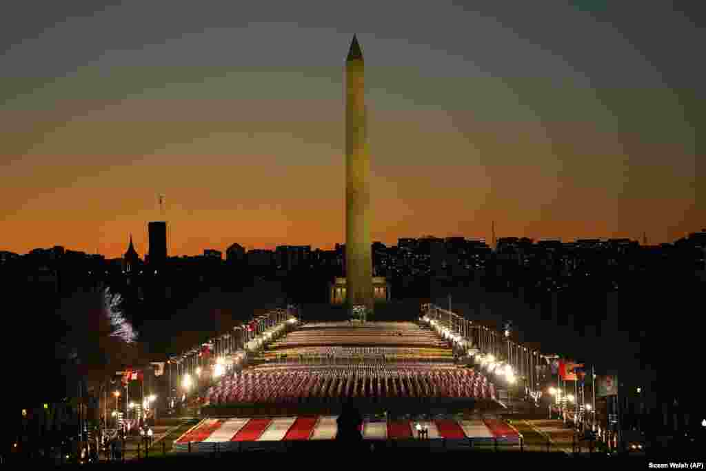 Un câmp de steaguri în apropiere de National Mall, cu Monumentul lui Washington în fundal. Marți, 19 ianuarie, 2021. Vedere dinspre aripa vestică a Capitoliului american, în seara dinaintea celei de-a 59-a ceremonii de inaugurare prezidențiale din Washington.&nbsp;