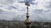 A cross from a church is seen against the backdrop of ongoing Russian shelling of the Azovstal steelworks on May 10.&nbsp;