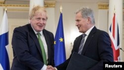 Premierul UK, Boris Johnson și președintele Finlandei, Sauli Niinisto, după semnarea protocolului privind asistența militară defensivă reciprocă, 11 mai 2022. Soldații britanici vor apăra Finlanda dacă va fi atacată înainte de ratificarea aderării ei la NATO de către statele membre.