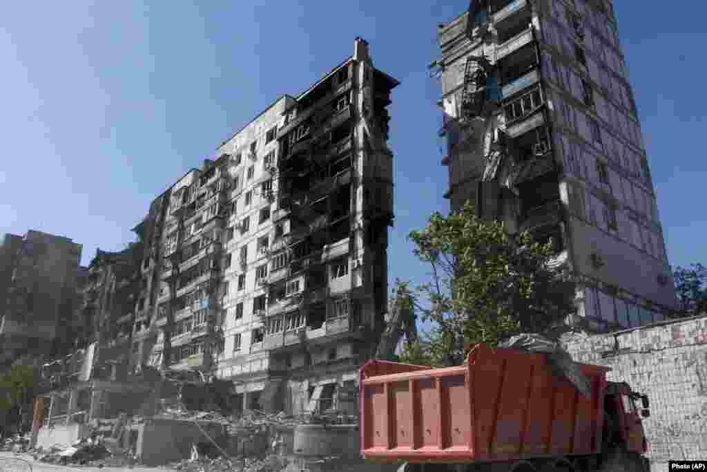 Munkások takarítják el a törmeléket az egyik lakónegyed romjainál május 12-én
