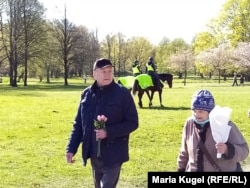 Пожилые русскоязычные рижане несут цветы к советскому памятнику в столице Латвии