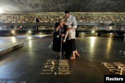 Пожилая израильтянка оплакивает свою семью в Зале памяти комплекса "Яд ва-Шем"
