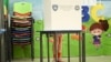 Një grua në kabinën e votimit në një vendvotim në Prishtinë më 7 qershor 2026. 