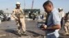 Iraqi police inspect a crater at the scene of the car bombing in Karbala.