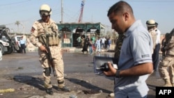 Iraqi police inspect a crater at the scene of the car bombing in Karbala.