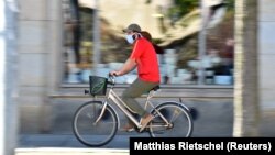 Германиянинг Дрезден шаҳрида ниқоб тақиб кетаётган велосипедчи, 2020 йил 20 апрели.