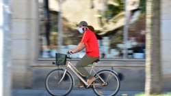 Велосипедист в маске на улице в германском Дрездене. 20 апреля 2020 года.