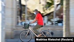 Велосипедист в маске на улице в германском Дрездене. 20 апреля 2020 года.