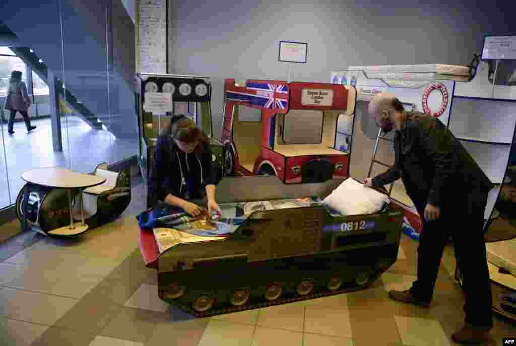 Anton Koppel, head of CaroBus furniture company, and an employee with a child's bed in the shape of a Buk missile launcher at the company's showroom in St. Petersburg. An international criminal investigation recently found that a Malaysia Airlines passenger jet was shot down by a Buk missile fired from separatist-controlled territory in Ukraine in 2014. Investigators found that the Buk was brought into Ukraine from Russia shortly before the tragedy and then smuggled back to Russia shortly afterward. (AFP/Olga Maltseva)