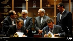 Iran -- Deputy of France's Peugeot Citroen (PSA) Jean-Christophe Quemard (R) signs a 400 million euro joint venture with Hashem Yekkeh-Zareh (L), the CEO of industrial group Iran Khodro, an old partner of PSA, in Tehran, June 21, 2016
