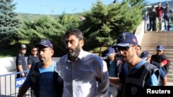 Сотрудники турецкой полиции ведут в здание суда военного, подозреваемого в причастности к попытке переворота. Мугла, 17 августа 2016 года.
