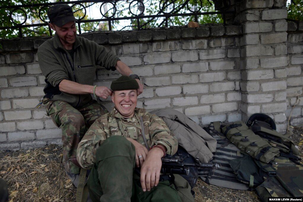 Ushtarë të ushtrisë ukrainase, nga Batalioni Ajdar, duke qeshur, teksa pushonin në fshatin Sçastja, afër qytetit lindor ukrainas të Luhanskut, më 22 shtator 2014.