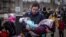 A man carries a girl as he and other families arrive at a train station to flee the eastern city of Kramatorsk, in the Donbas region, on April 4.