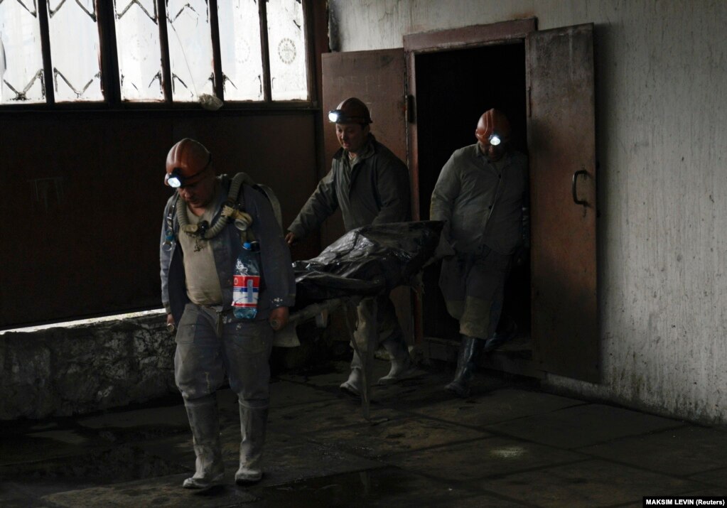 Disa burra duke bartur trupin e një viktime të një shpërthimi në minierën Skoçinski, afër Donjeckut, më 11 prill 2014. Shtatë njerëz u vranë kur një shpërthim, i shkaktuar nga një rrjedhje gazi, goditi minierën e qymyrit, afër qytetit lindor ukrainas.