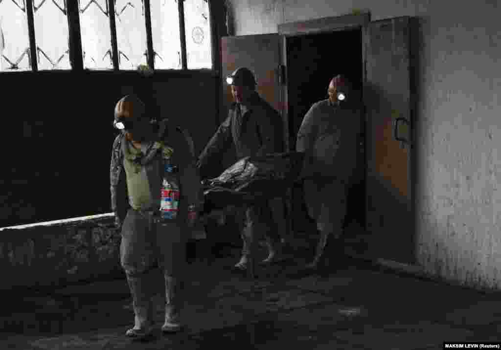 Bányászok viszik a Donyeck melletti Szkocsinszkij bányában történt robbanás egyik áldozatának holttestét 2014. április 11-én. Hét ember meghalt, amikor a kelet-ukrajnai város közelében lévő szénbányában berobbant a szivárgó gáz