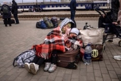 Doi copii așteaptă să se îmbarce într-un tren în gara centrală din Kramatorsk, pe 5 aprilie 2022.