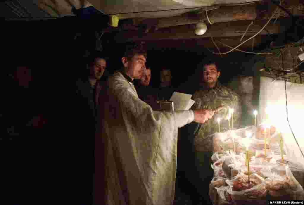 A priest blesses cakes to mark Orthodox Easter with Ukrainian troops on the front line in Ukraine&#39;s eastern Luhansk region on April 16, 2017.