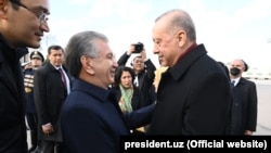 Özbegistanyň prezidenti Şawkat Mirziýoýew (çepde) Daşkende sapar bilen gelen Türkiýäniň prezidenti Rejep Taýýyp Erdogany garşylaýar. 2022-nji ýylyň 29-njy marty.
