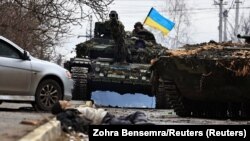 Trupul neînsuflețit al unui civil ucrainean, despre care localnicii spun că a fost ucis de trupele ruse, zace pe o stradă din Bucea, regiunea Kiev, Ucraina, 2 aprilie 2022.