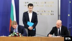Премиерът Кирил Петков наблюдава как Атанас Бостанджиев (вдясно) от Gemcord и Майкъл Хюит от IP3 подписват меморандума на 23 март в Министерския съвет.