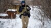 Ukrainian photographer Maksim Levin carries a cat near the line of separation from Russia-backed separatists in Ukraine&#39;s Donetsk region on January 25, 2022.