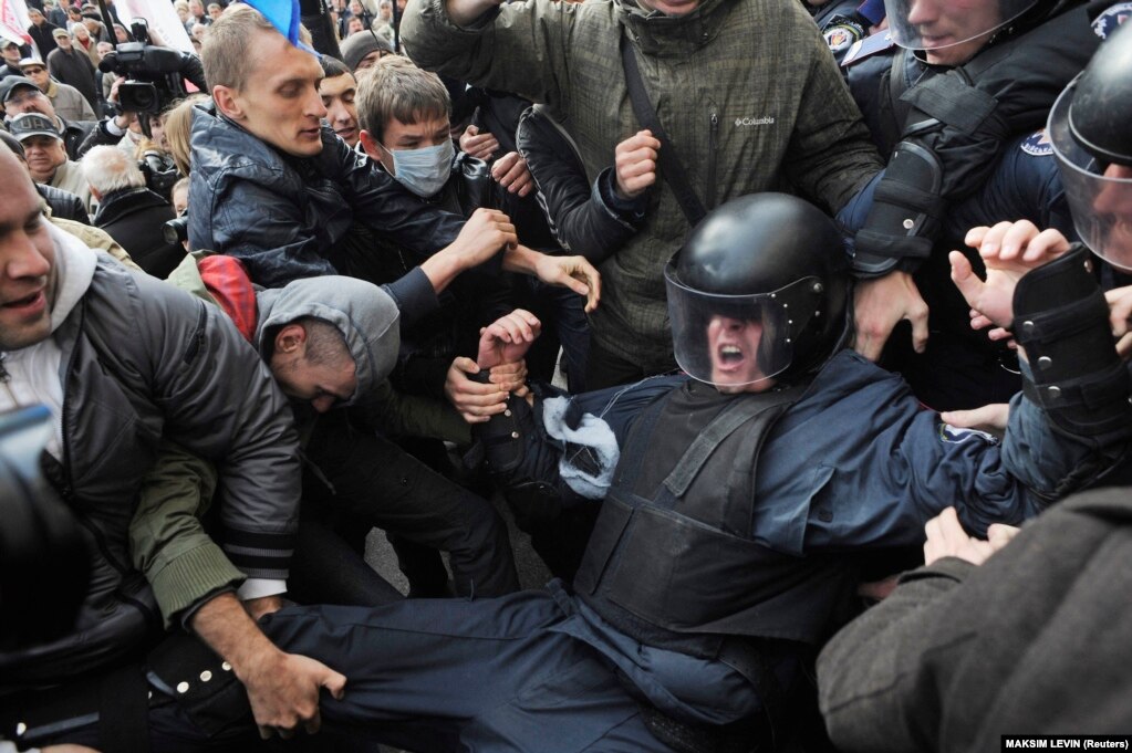 Aktivistët e partive opozitare ukrainase duke u përleshur me policinë kundër trazirave, më 2 tetor 2013, teksa përpiqeshin të hynin në zyrën e kryetarit të Kievit, gjatë një proteste kundër shtyrjes së zgjedhjeve për kryetar.