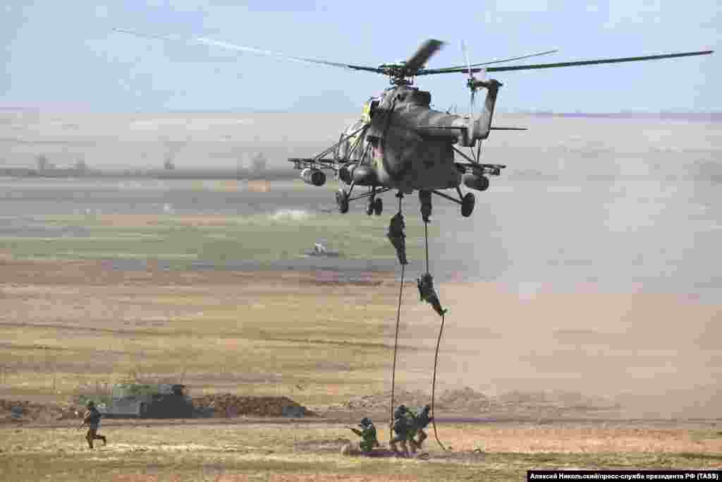 Russian troops rappel out of an armed transport helicopter in western Russia.