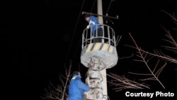 Электрики восстанавливают линии электропередач, оборванные шквальным ветром. Каратау, 12 января 2013 года. Фото из социальной сети Facebook.