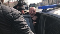 Полиция силой заталкивает активиста Мурата Аштаева в машину. Шымкент, 1 марта 2020 года.