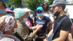 Женщины, требующие от властей разрешить торговлю на улице вблизи рынка, беседуют с представителем акимата. Нур-Султан, 14 июля 2020 года.