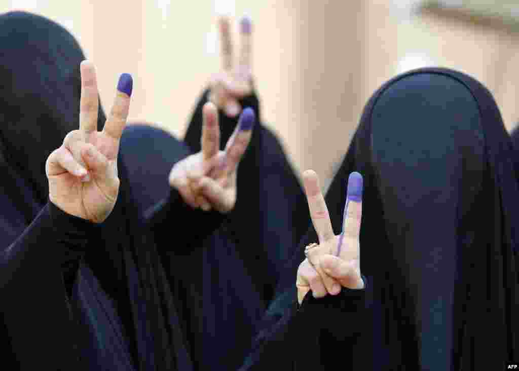 Iraqi women flash the sign for victory with ink-stained fingers after voting in Iraq&#39;s parliamentary elections in Baghdad on April 30. (Sabah Arar, AFP)