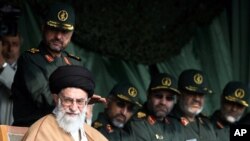 In front of Iranian Revolutionary Guards commanders, supreme leader Ayatollah Ali Khamenei, bottom left, attends a gathering of Basij paramilitary forces, in Tehran, Iran, Monday, Nov. 26, 2007.