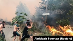Ljudi pokušavaju da ugase požar u planinskoj provinciji Tizi Ouzou, istočno od Alžira, 10. august 2021.