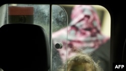 A young girl looks out from the back of an ambulance as it arrives in the port city of Misurata on April 17.