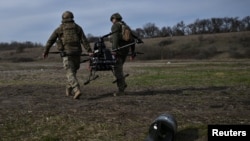 Militarii ucraineni transportă o dronă de atac grea înaintea unui zbor de testare pe un poligon de instrucție din regiunea Zaporijia, la 26 martie 2026.