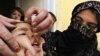 An Afghan health worker drops polio vaccine into the mouth of a child during a vaccination campaign in Kabul in 2009. It's still unclear whether a young woman shot dead in eastern Afghanistan recently was working on such a campaign and, if so, if that is why she was killed.