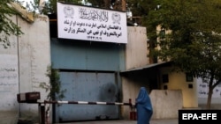A woman walks past the former Women's Affairs Ministry, which the Taliban has replaced with the Ministry for the Promotion of Virtue and Prevention of Vice.