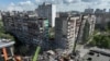 Firefighters work at a site of the apartment building damaged during a Russian missile and drone strike in Kyiv on May 14, 2026.