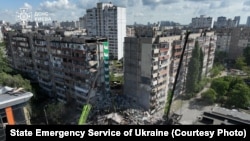 Спасатели на месте удара по жилому дому в Дарницком районе Киева, Украина, 14 мая 2026 года